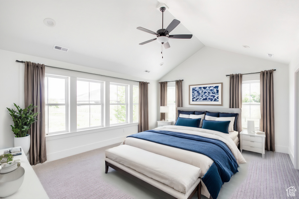 Carpeted bedroom featuring ceiling fan and lofted ceiling