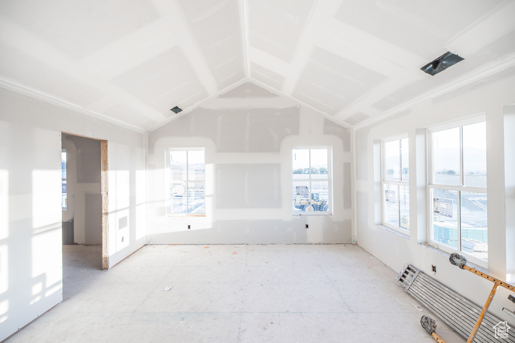 Empty room with lofted ceiling