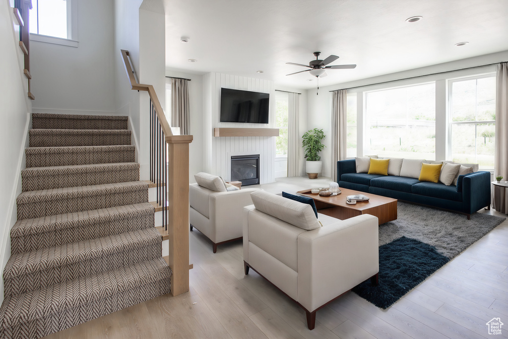 Living room featuring a wealth of natural light, ceiling fan, and light hardwood / wood-style flooring