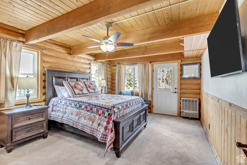 Bedroom with ceiling fan, wooden ceiling, beamed ceiling, light colored carpet, and log walls