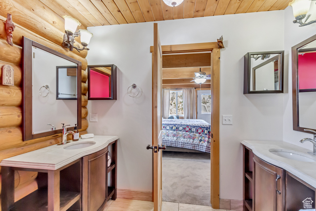 Bathroom featuring wooden ceiling, vaulted ceiling, vanity, and ceiling fan