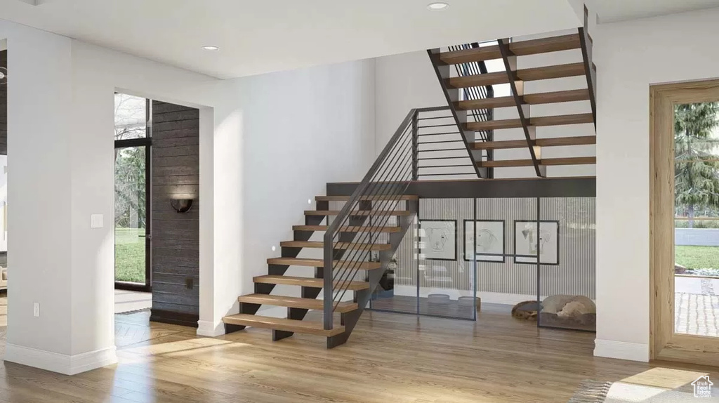 Stairway with hardwood / wood-style flooring and a wealth of natural light