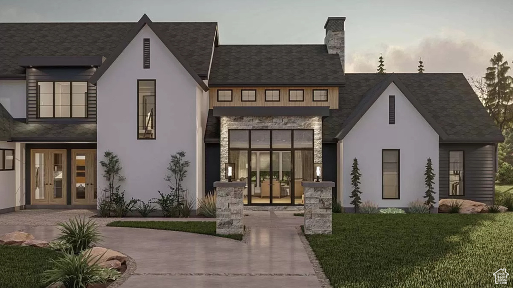 View of front of house featuring french doors and a lawn