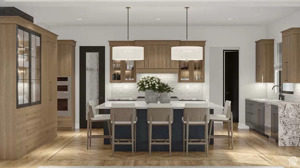 Kitchen featuring hanging light fixtures, a kitchen island, light parquet flooring, and backsplash