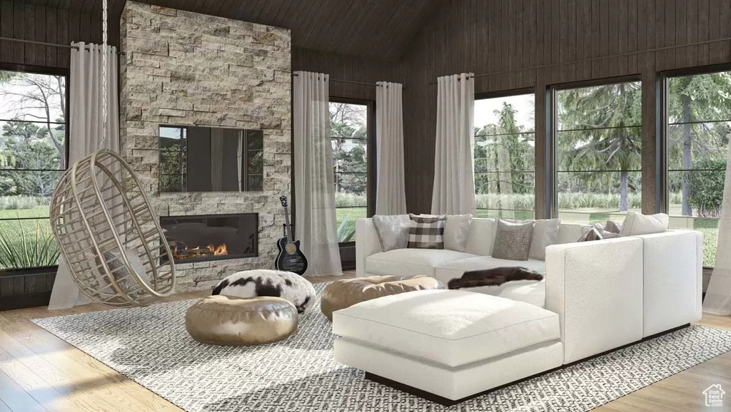 Living room featuring a stone fireplace, vaulted ceiling, and hardwood / wood-style floors