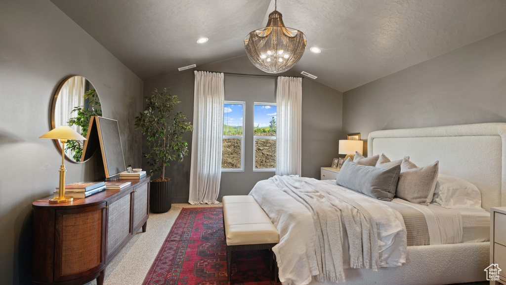 Bedroom with light colored carpet, a chandelier, and lofted ceiling