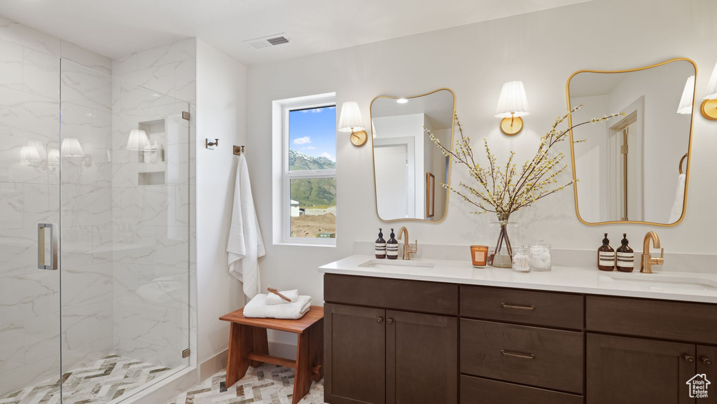 Bathroom with a shower with shower door and dual bowl vanity