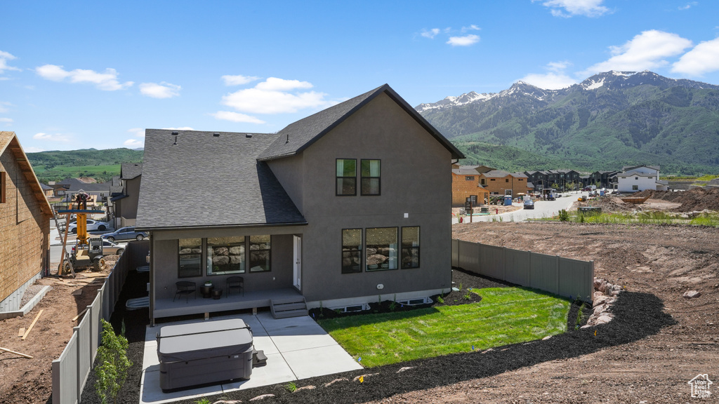 Rear view of house with a patio and a mountain view