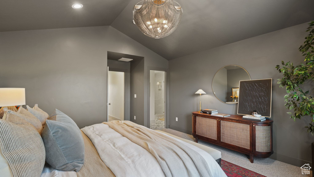 Bedroom with ensuite bath, a notable chandelier, vaulted ceiling, and carpet flooring