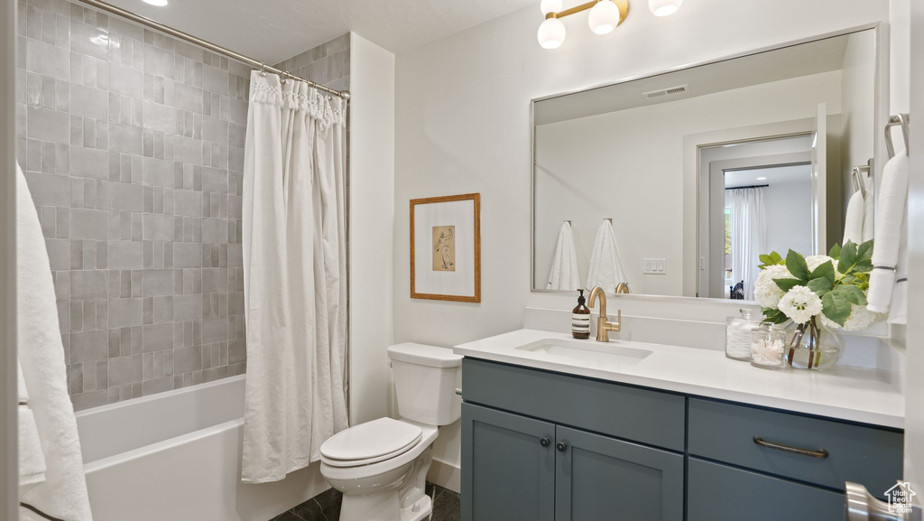 Full bathroom with vanity, toilet, and shower / bath combo with shower curtain