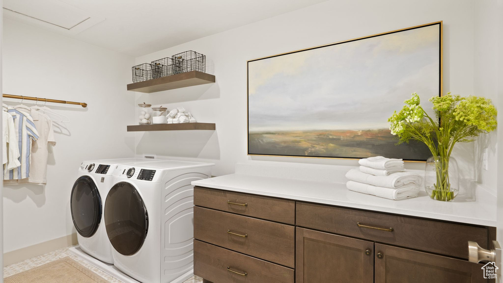 Clothes washing area with light tile floors and washing machine and dryer