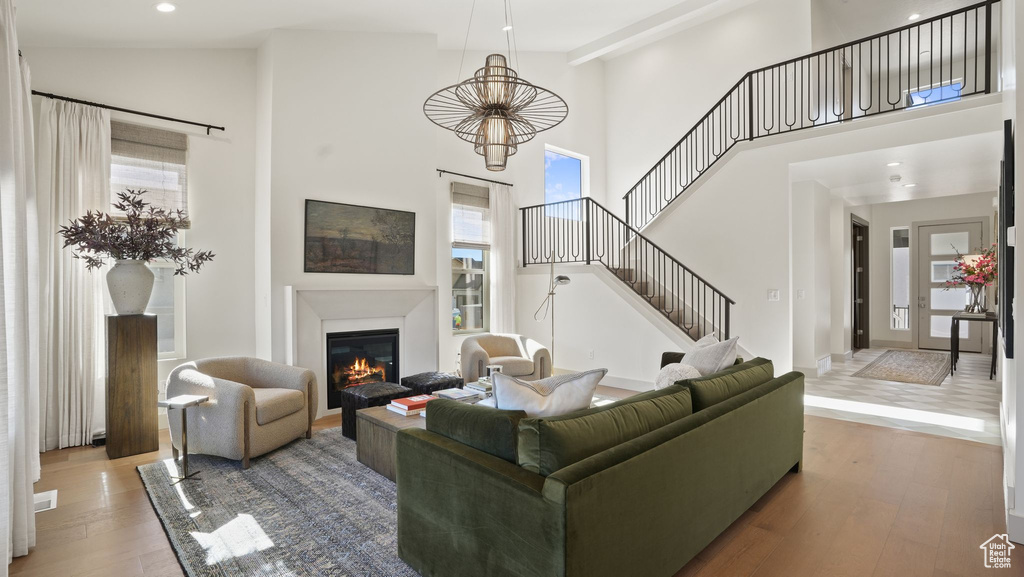 Living room with high vaulted ceiling and hardwood / wood-style flooring