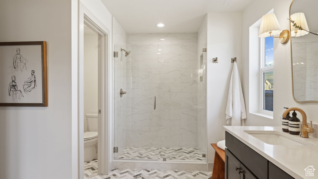 Bathroom featuring an enclosed shower, toilet, tile floors, and large vanity