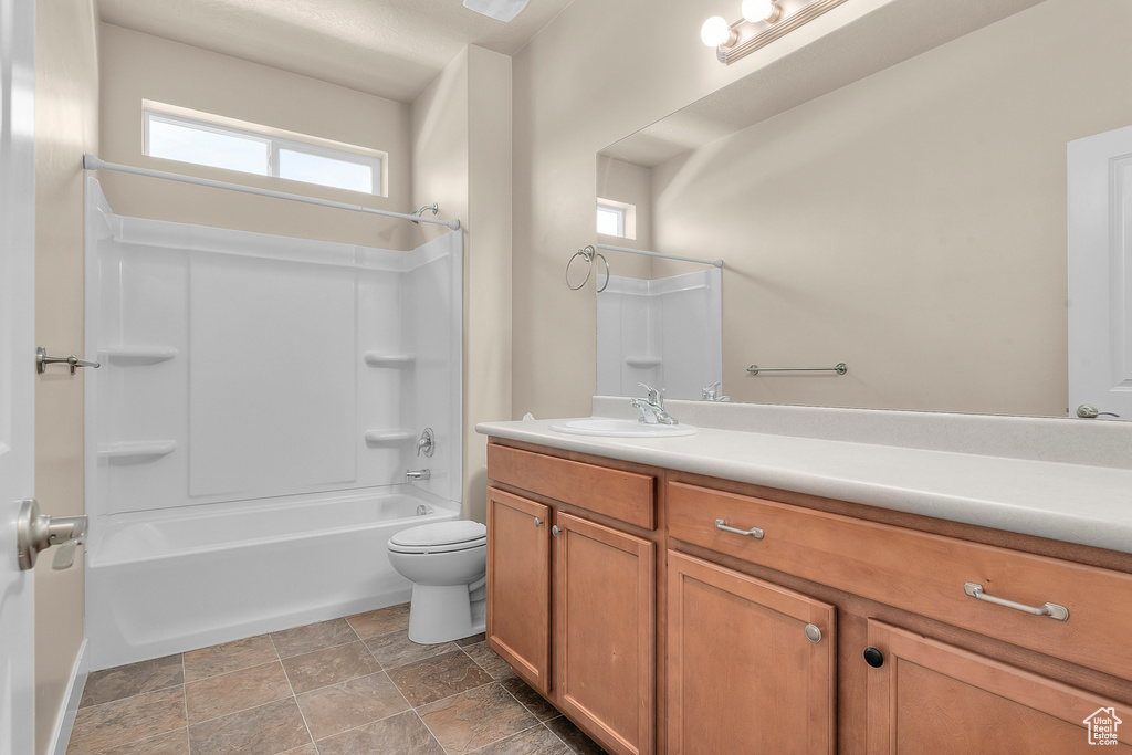 Full bathroom featuring vanity with extensive cabinet space, toilet, shower / bathing tub combination, and tile flooring