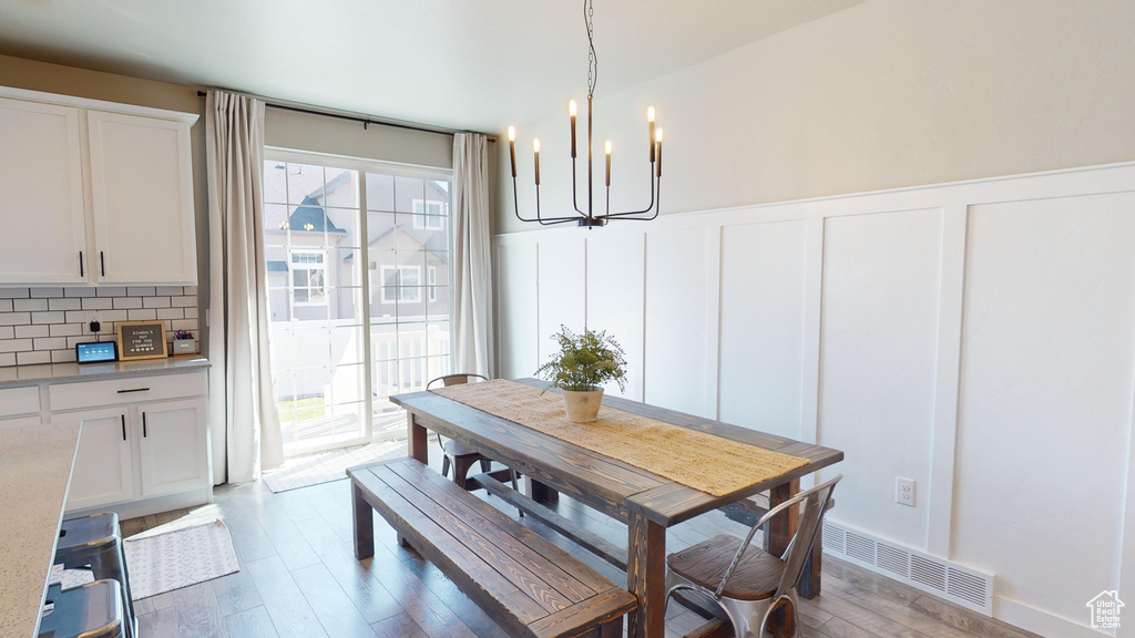 Dining room with an inviting chandelier and hardwood / wood-style floors