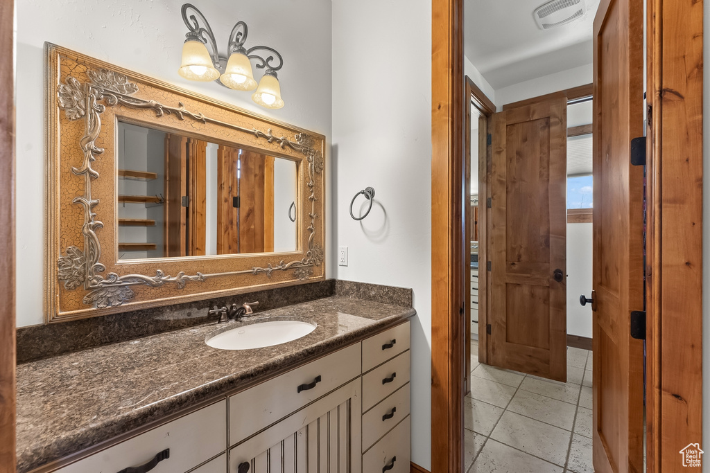 Bathroom featuring tile floors and vanity with extensive cabinet space