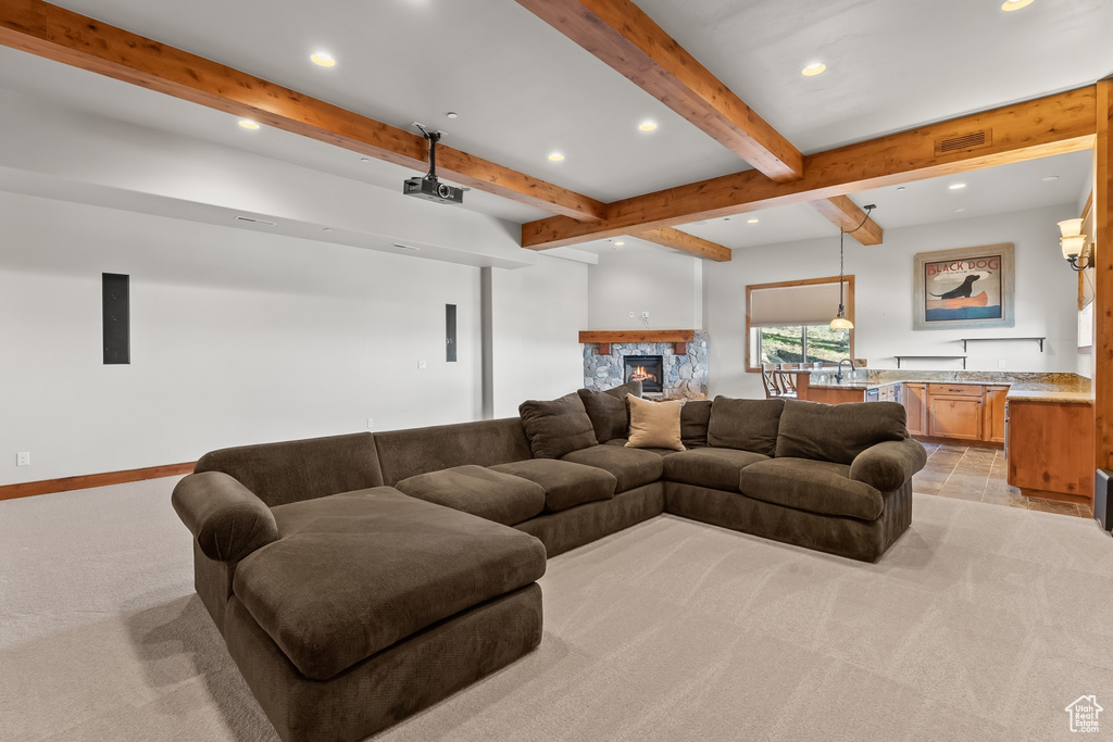 Living room with beamed ceiling, a fireplace, and light carpet