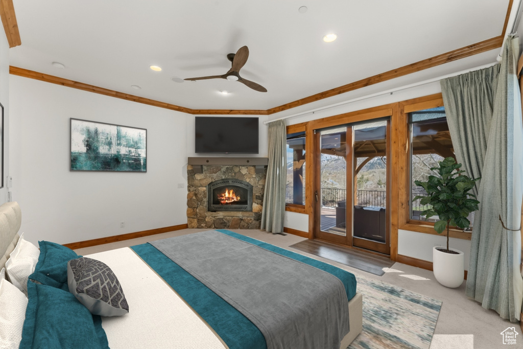 Bedroom featuring access to outside, crown molding, a fireplace, and ceiling fan