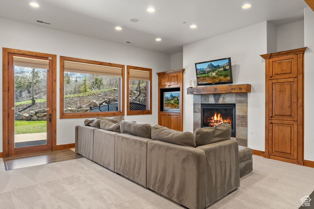 Carpeted living room featuring a tile fireplace