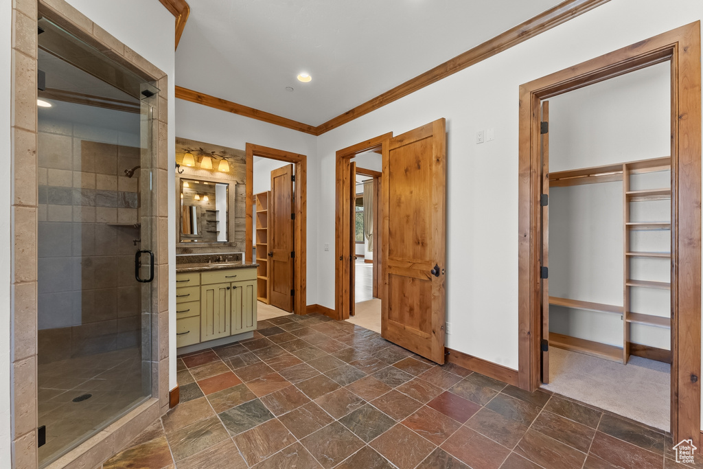 Bathroom with an enclosed shower, vanity, tile floors, and ornamental molding