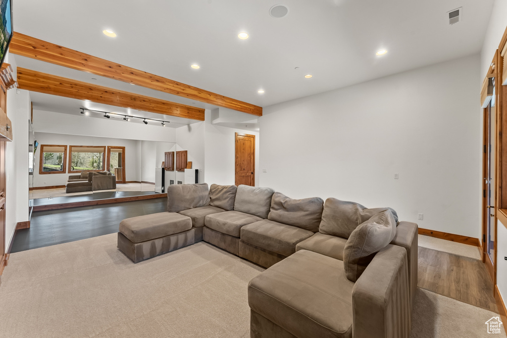 Living room featuring wood-type flooring, beam ceiling, and track lighting