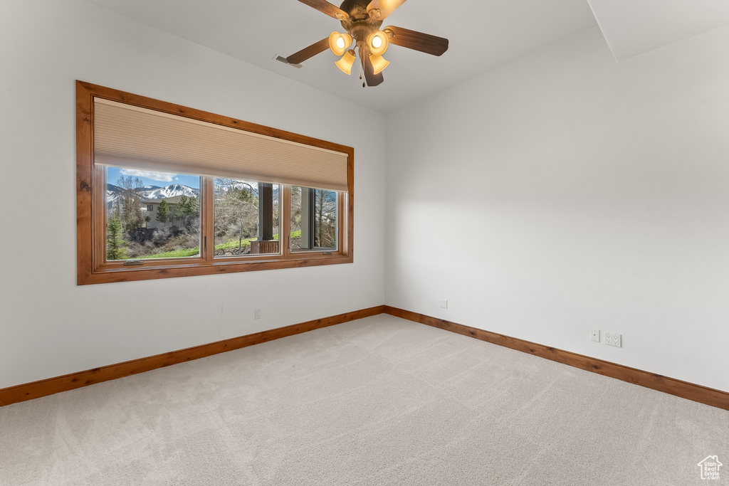 Carpeted spare room featuring ceiling fan