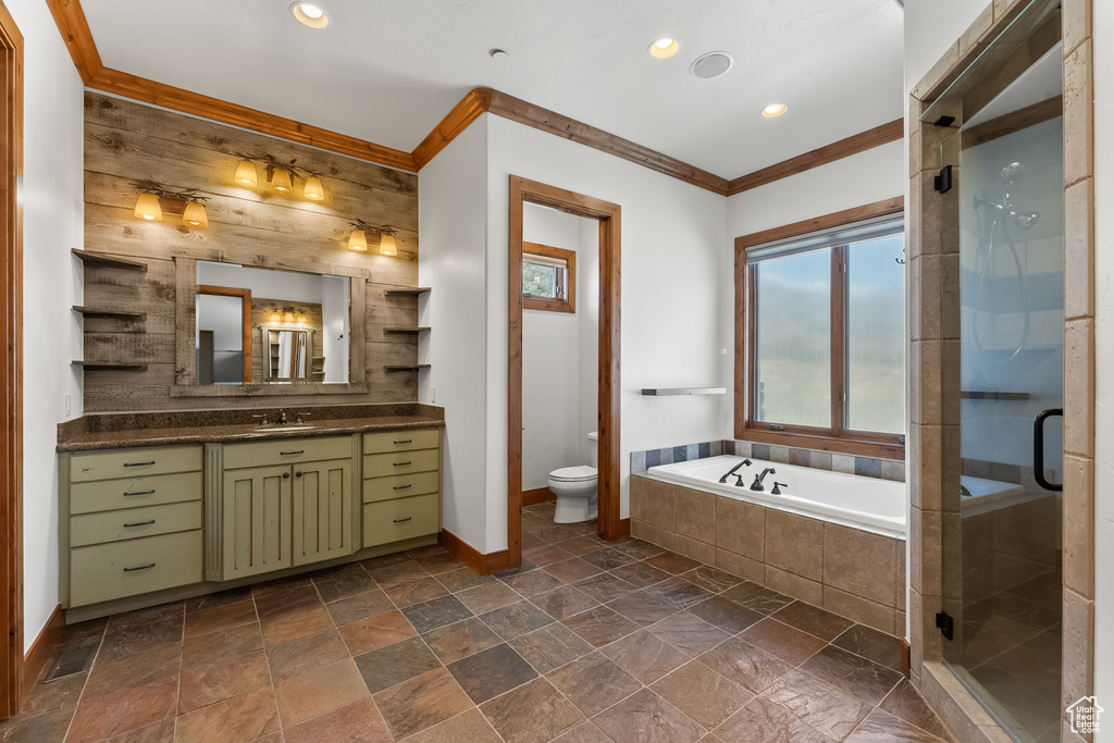 Full bathroom with tile floors, separate shower and tub, vanity, and toilet