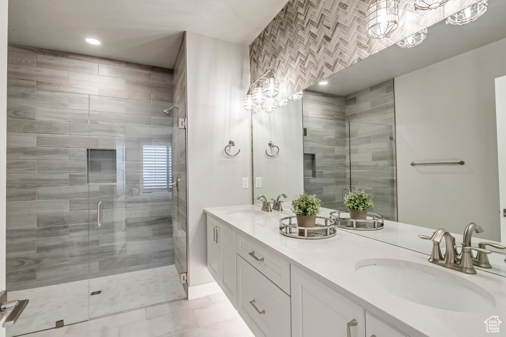 Bathroom featuring walk in shower, tile flooring, large vanity, and dual sinks