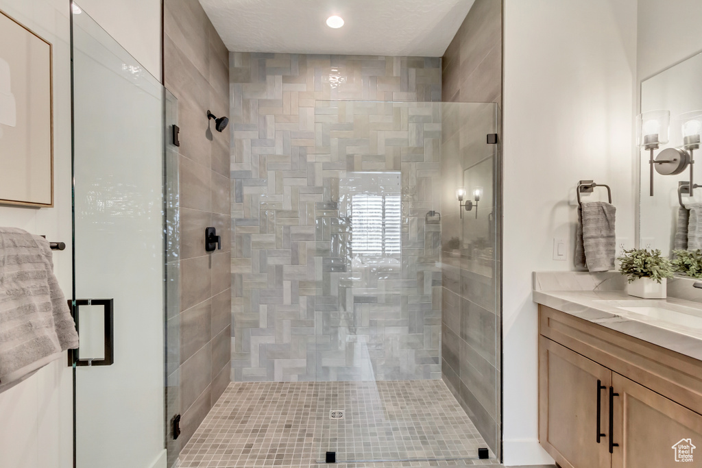 Bathroom featuring vanity and a shower with door