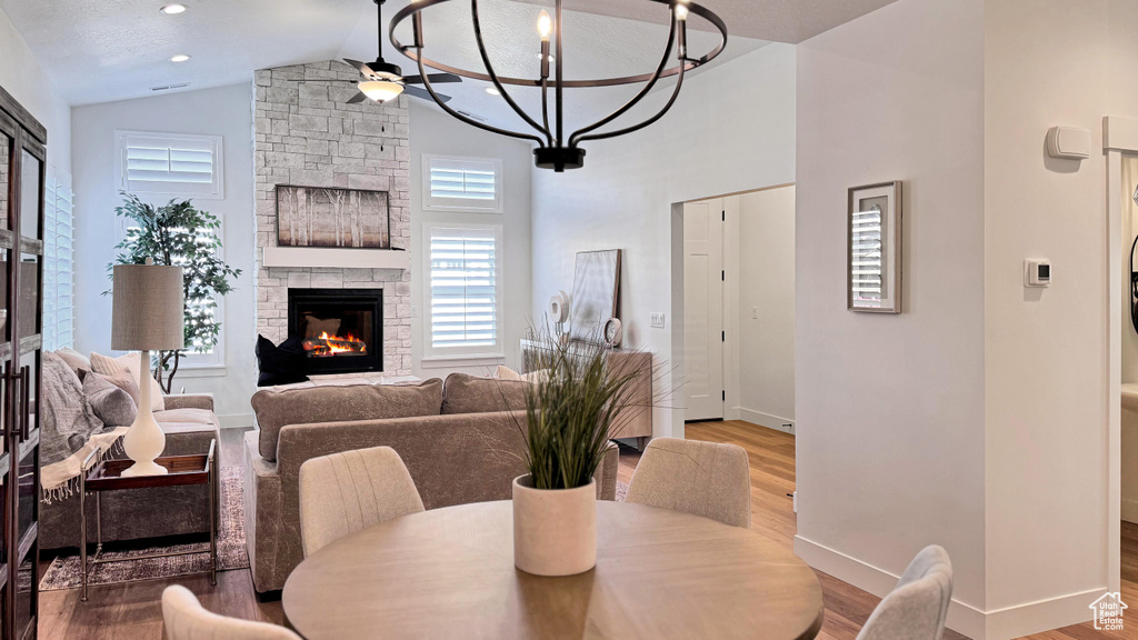 Dining space with a textured ceiling, hardwood / wood-style flooring, ceiling fan, and a fireplace