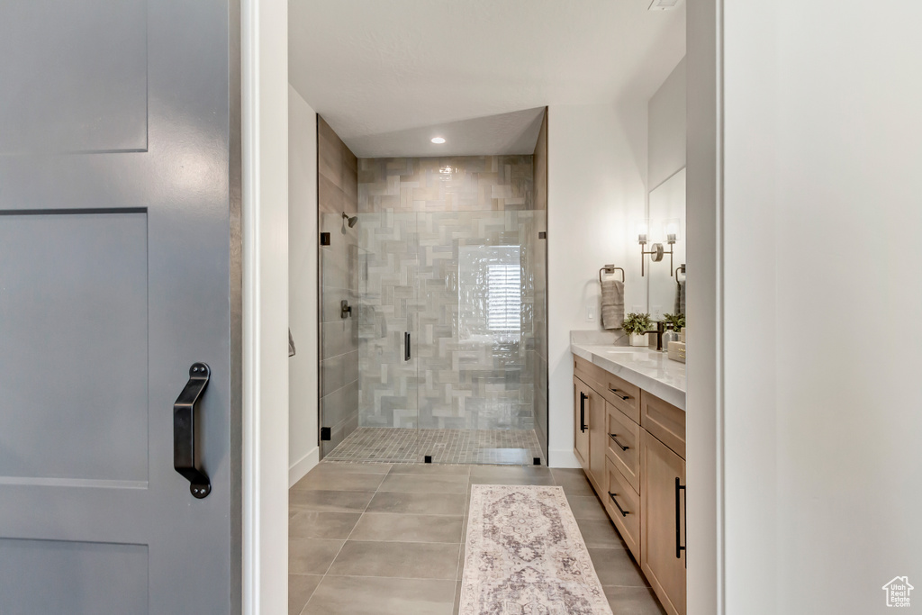 Bathroom with vanity, tile patterned flooring, and a shower with shower door