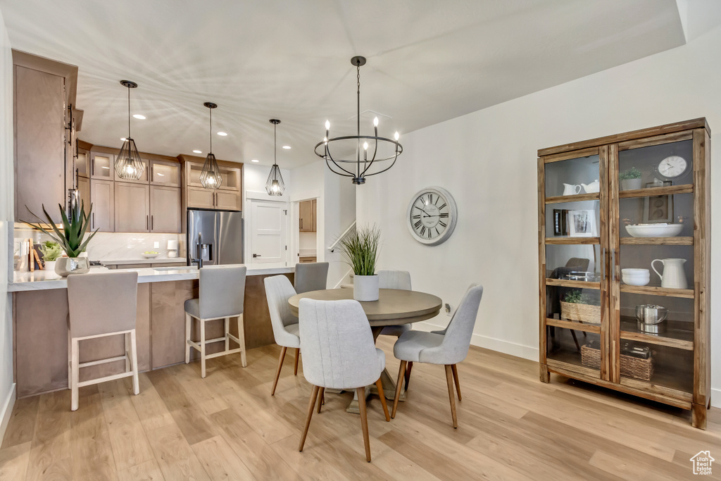 Dining room featuring light wood-type flooring and a chandelier