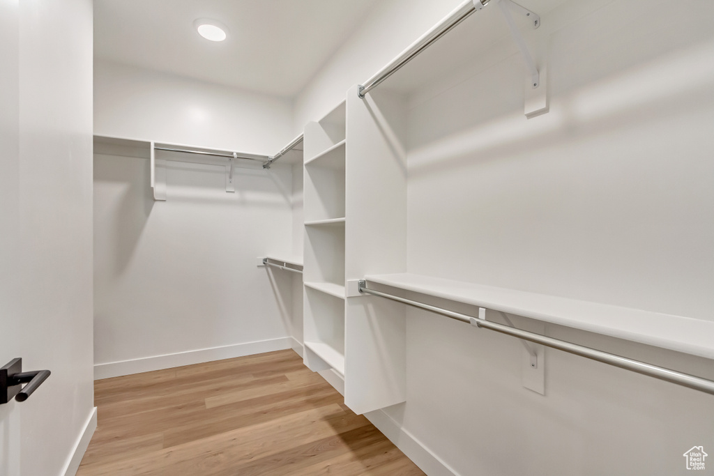 Walk in closet with light wood-type flooring