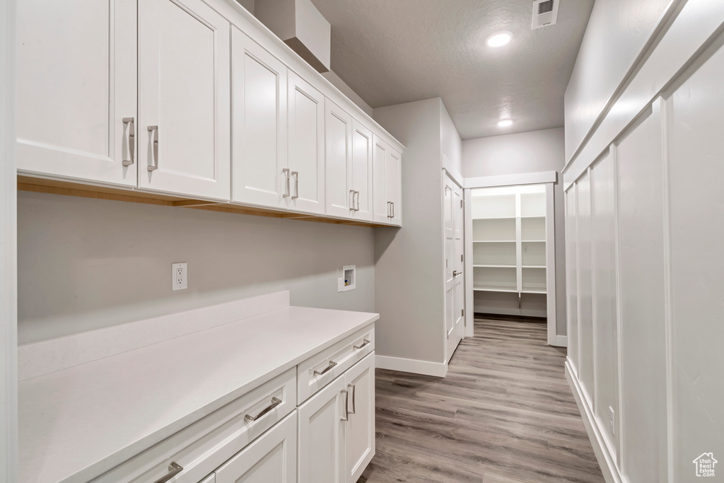 Interior space featuring light hardwood / wood-style floors, cabinets, and washer hookup