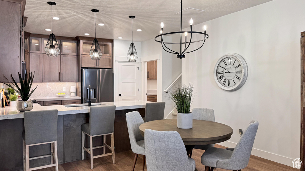 Dining room with dark hardwood / wood-style flooring and a notable chandelier