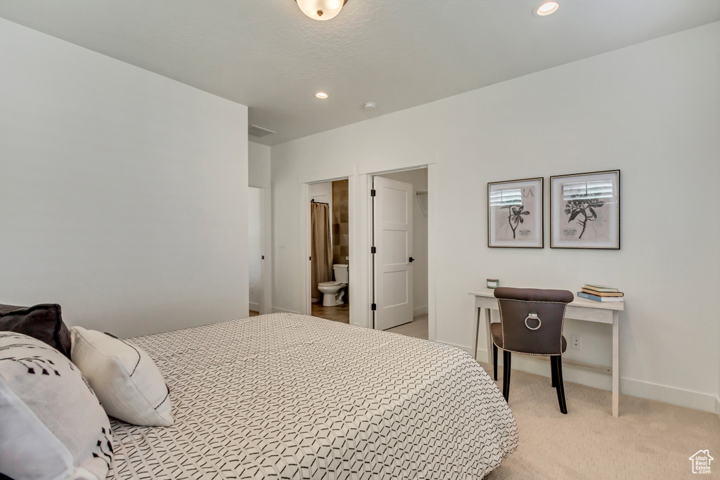 Carpeted bedroom featuring ensuite bathroom
