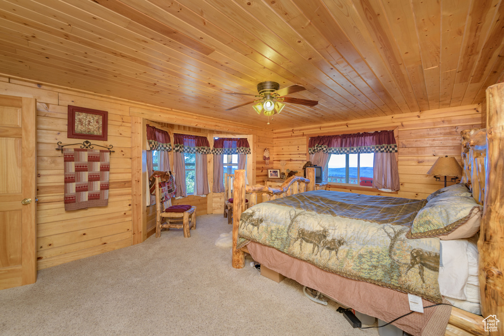 Bedroom with wooden ceiling, carpet, and wood walls