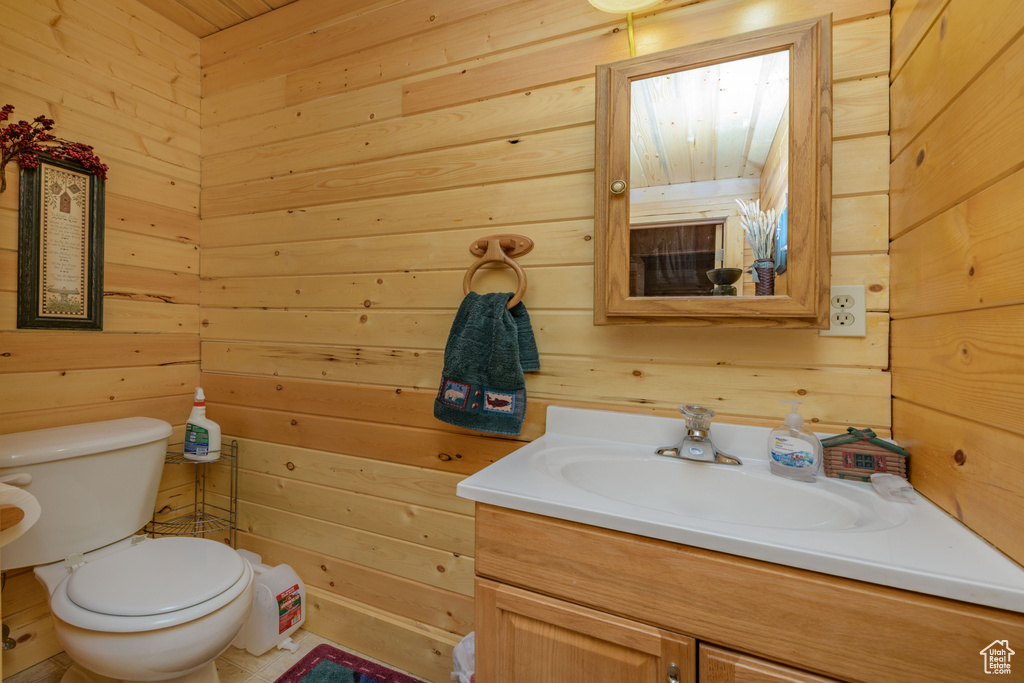 Bathroom featuring wooden walls, oversized vanity, and wood ceiling