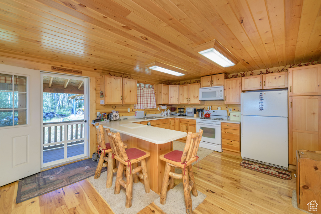 Kitchen featuring white appliances, light hardwood / wood-style floors, wood ceiling, and light brown cabinetry