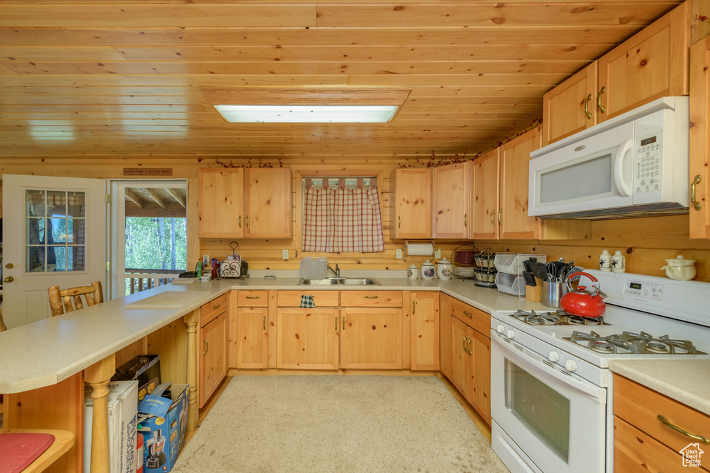 Kitchen with light brown cabinets, sink, white appliances, and wood ceiling