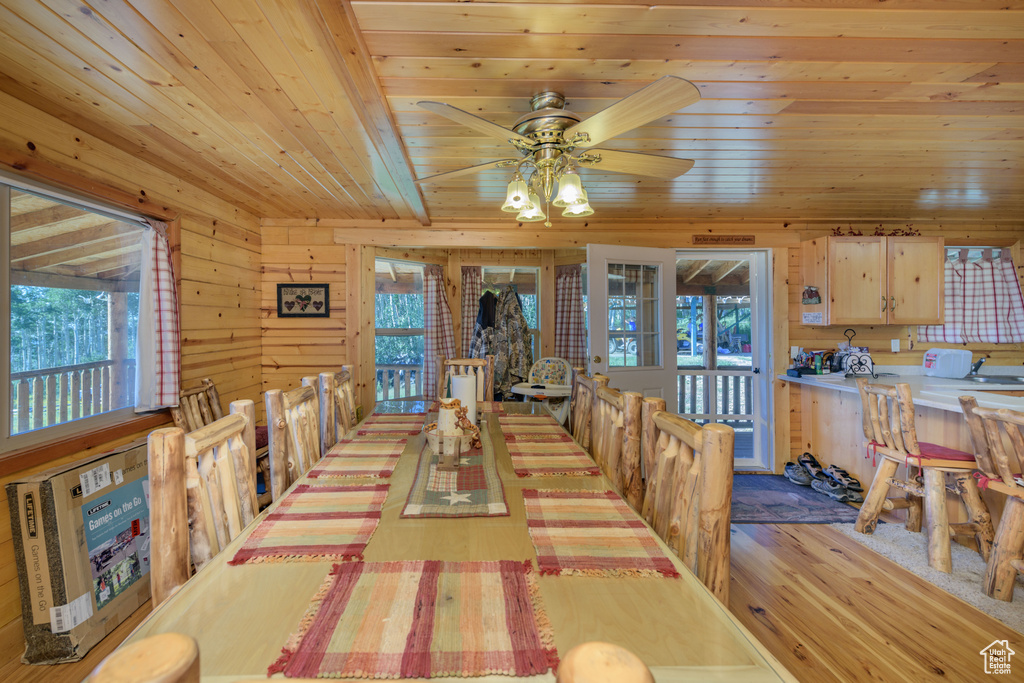 Dining room with a healthy amount of sunlight, wood ceiling, and light hardwood / wood-style flooring