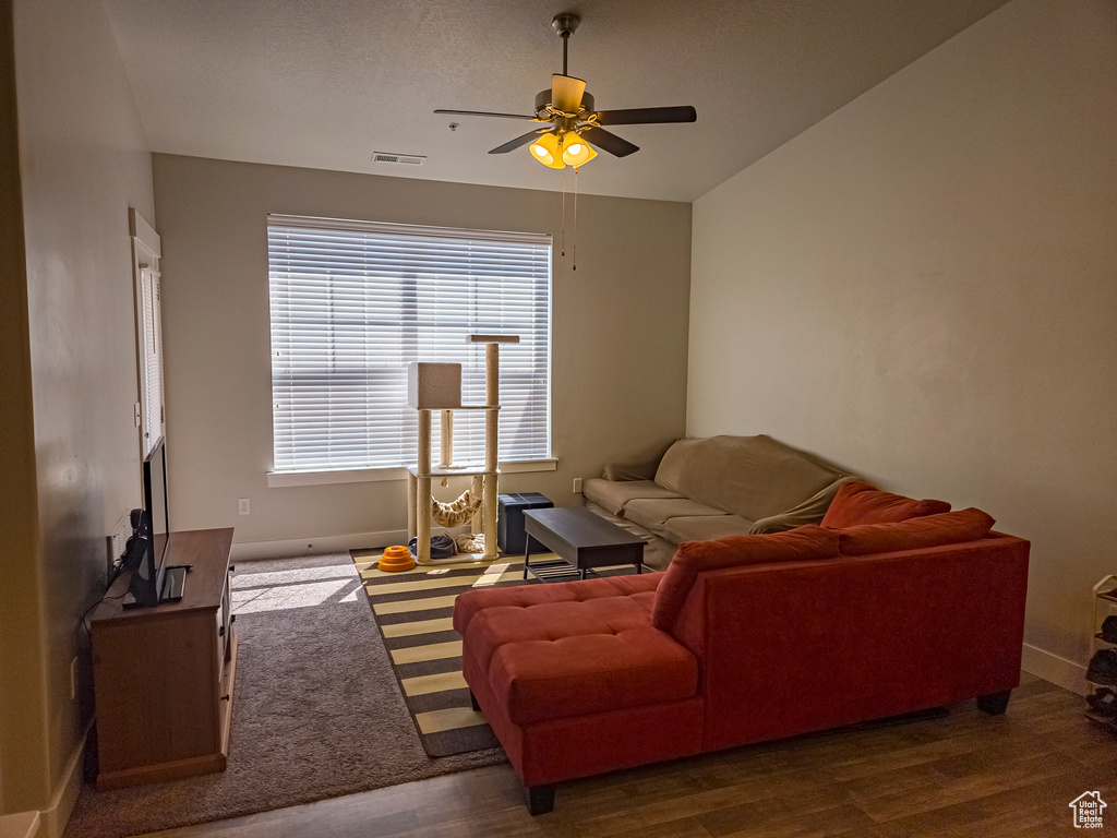 Living room featuring lofted ceiling, dark wood-type flooring, and ceiling fan