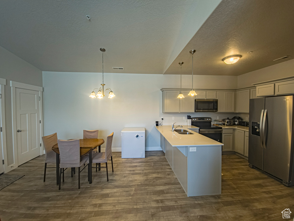 Kitchen with sink, hanging light fixtures, kitchen peninsula, and stainless steel appliances