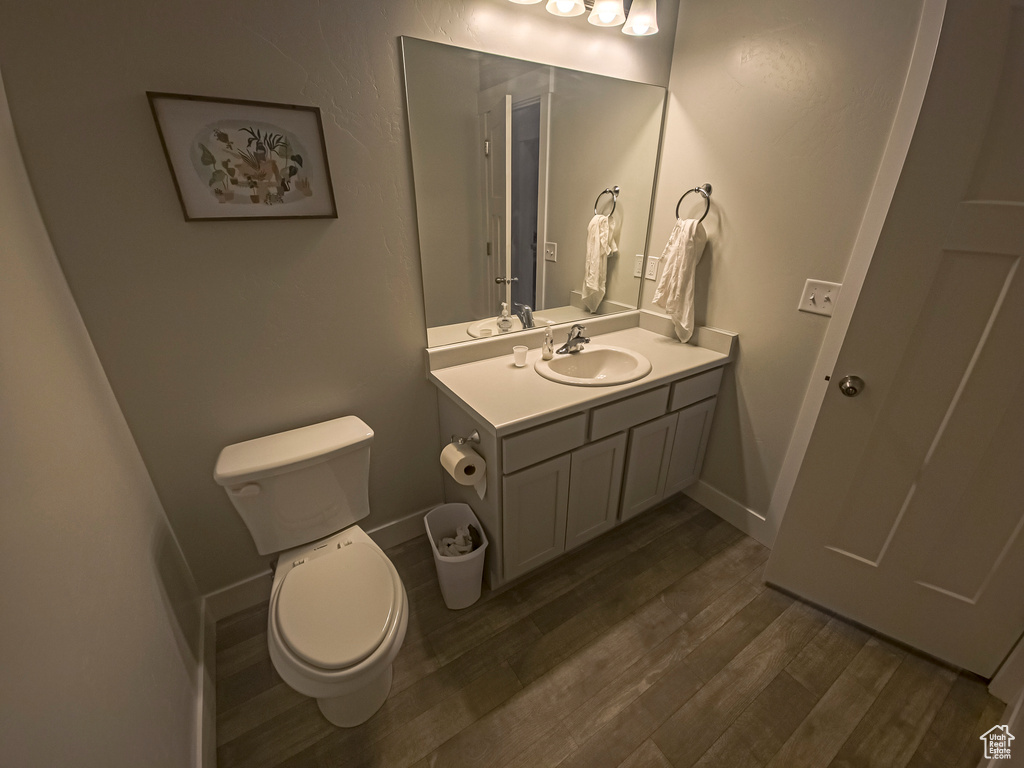 Bathroom featuring hardwood / wood-style floors, vanity, and toilet