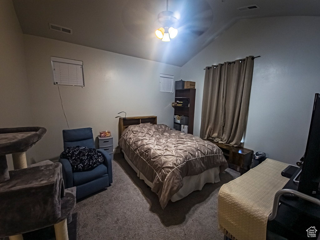 Carpeted bedroom with ceiling fan and lofted ceiling