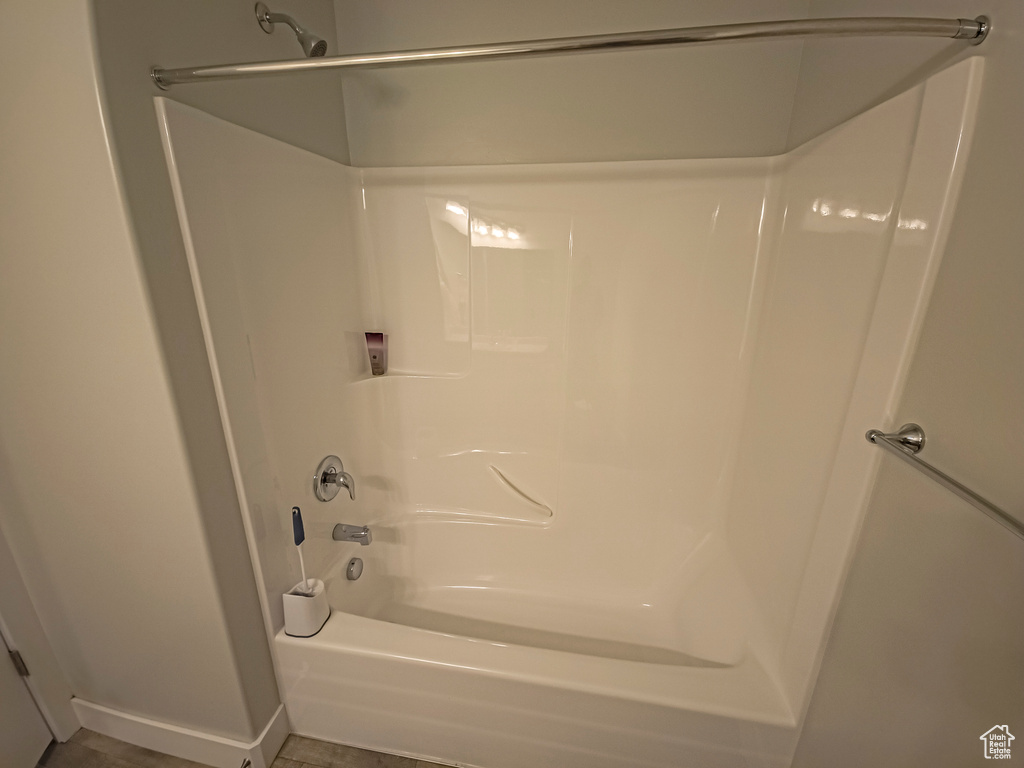 Bathroom featuring bathtub / shower combination and tile flooring