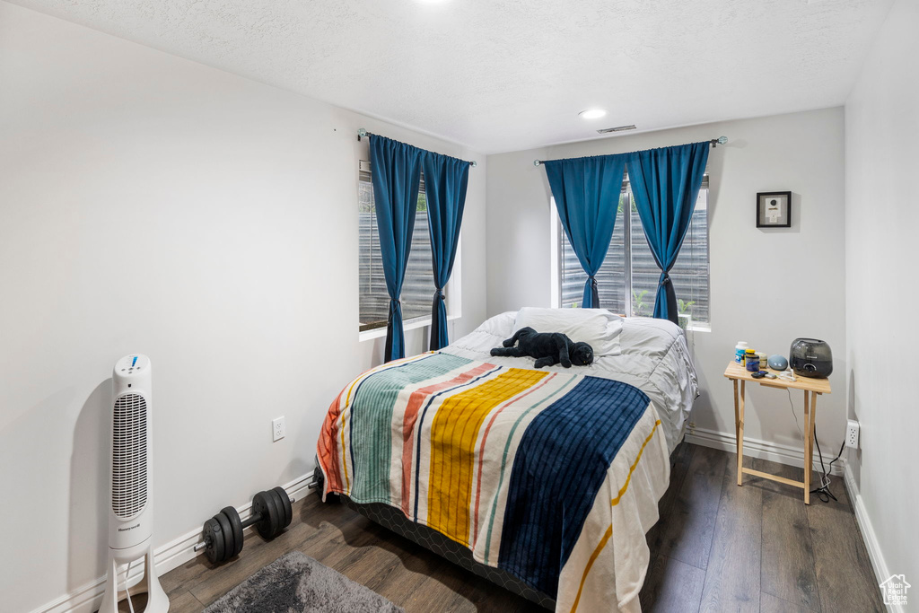 Bedroom with a textured ceiling and wood-type flooring