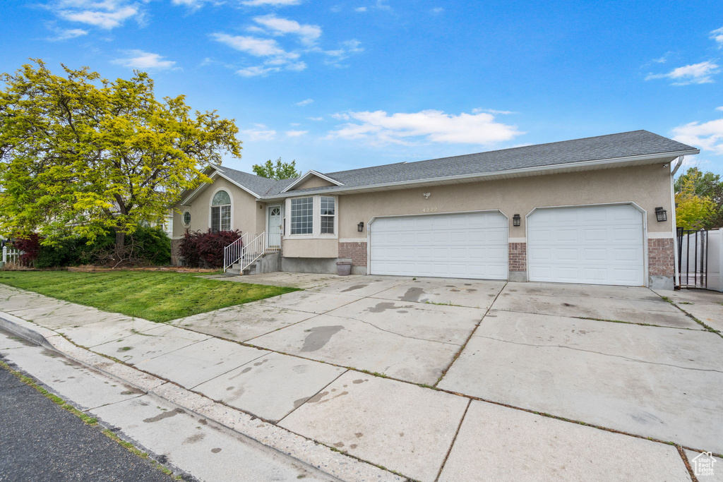 Ranch-style home featuring a garage and a front yard