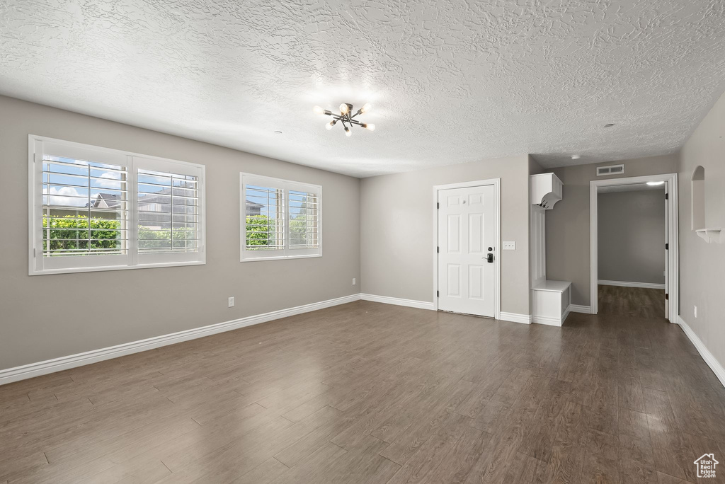 Interior space featuring a textured ceiling and dark hardwood / wood-style floors