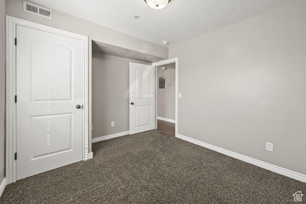 Unfurnished bedroom with dark carpet